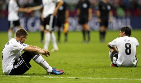  Pemain Jerman Holger Badstuber (kiri) dan Mesut Oezil (kanan) tampak kecewa setelah menelan kekalahan dari Italia dengan skor 2-1.  (Matthias Schrader/AP)