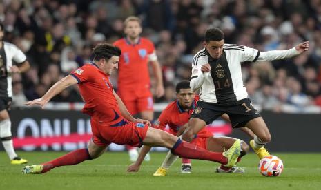 Pemain Jerman Jamal Musala, kanan, berebut bola dengan pemain Inggris Harry Maguire selama pertandingan sepak bola UEFA Nations League antara Inggris dan Jerman di stadion Wembley di London, Senin, 26 September 2022. 