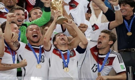 Pemain Jerman merayakan dengan trofi mereka setelah Piala Dunia pertandingan sepak bola final antara Jerman dan Argentina di Stadion Maracana di Rio de Janeiro, Brasil, Minggu(13/7). (AP/Matthias Schrader).