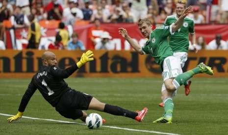 Pemain Jerman Per Martesacker (kanan) gagal menaklukkan kiper AS Tim Howard pada laga persahabatan di RFK Stadium, Washington, Senin (3/6) dini hari WIB. Jerman kalah 3-4 pada laga tersebut.