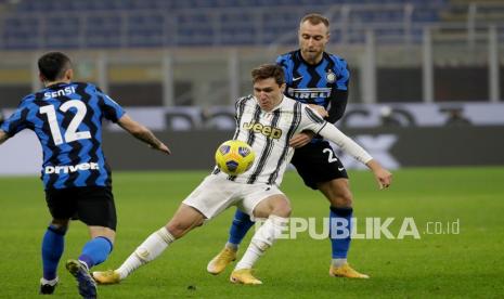 Pemain Juventus Federico Chiesa (latar depan) dan pemain Inter Milan Christian Eriksen memperebutkan bola pada pertandingan sepak bola leg pertama semifinal Piala Italia antara Inter Milan dan Juventus di stadion San Siro, di Milan, Italia, Rabu (3/2) dini hari WIB. 