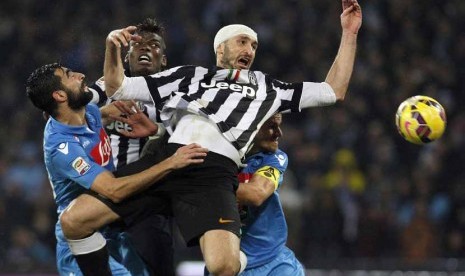 Legenda Juventus, Giorgio Chiellini (depan), melompat berebut bola dalam laga lawan Napoli di kancah Serie A Italia di San Paolo, Naples, beberapa waktu lalu. 