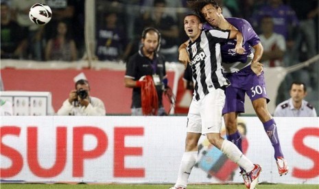 Pemain Juventus, Giorgio Chiellini (kiri), berebut bola dengan striker Fiorentina, Luca Toni, di laga Liga Italia di Stadion Artemio Franchi, Florence, Selasa (25/9).