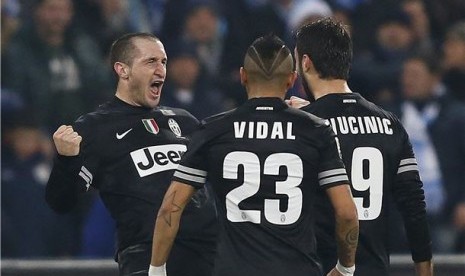 Pemain Juventus, Giorgio Chiellini (kiri), melakukan selebrasi saat menghadapi Napoli di laga Seri A Italia di San Paolo, Napoli, Jumat (1/3).  