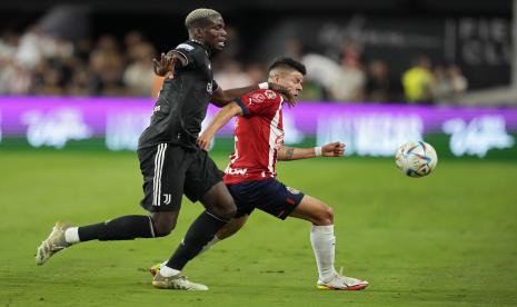 Pemain Juventus Paul Pogba, kiri, dan pemain Chivas Pavel Perez berebut bola pada paruh pertama pertandingan persahabatan sepak bola Jumat, 22 Juli 2022, di Las Vegas. 