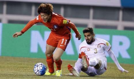 Pemain Korea Selatan Hwang Ui-Jo beraksi melawan Youssef Mohamad dari  Lebanon dalam pertandingan penyisihan Piala Dunia 2018. 