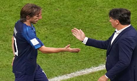  Pemain Kroasia Luka Modric (kiri) meninggalkan lapangan dan berjabat tangan dengan pelatih kepala Kroasia Zlatko Dalic setelah digantikan dalam pertandingan sepak bola semifinal Piala Dunia antara Argentina dan Kroasia di Stadion Lusail di Lusail, Qatar, Rabu (14/12) dini hari WIB. 