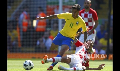 Pemain Kroasia Sime Vrsaljko menekel  pemain Brasil Philippe Coutinho pada laga persahabatan antara Brasil dan Kroasia di Anfield Stadium di Liverpool, Inggris, Ahad (3/6).