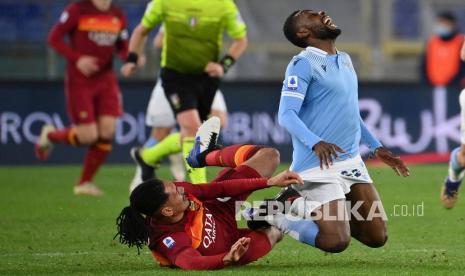 Pemain Lazio Jean-Daniel Akpa Akpro (kanan) dan pemain Roma Chris Smalling (kiri) beraksi pada pertandingan sepak bola Serie A antara Lazio dan Roma, di Stadion Olimpiade Roma, Sabtu (16/1) dini hari WIB. 