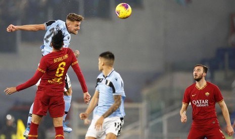 Pemain Lazio Sergej Milinkovic-Savic (kiri biru) berduel dengan bek AS Roma Chris Smalling (kiri merah) dalam pertandingan Liga Italia di Stadion Olimpico, Roma, Senin (27/1) dini hari WIB.