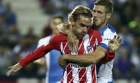 Pemain Leganes Ruben Perez (kiri) berduel dengan pemain Atletico Madrid Antoine Griezmann pada laga ketujuh La Liga antara kedua tim di Stadion Butarque, Leganes, Madrid, Spanyol, Sabtu (30/9). 