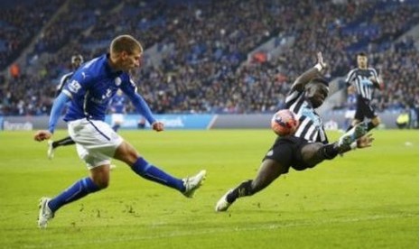 Pemain Leicester City Marc Albrighton (biru) melepaskan umpan dijaga oleh pemain Newcastle United Massadio Haidara dalam pertandingan Piala FA, Sabtu (3/1).