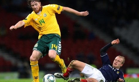 Pemain Lithuania Linas Pilibaitis (kiri) mendapat halangan dari pemain Skotlandia Steven Naismith (kanan) dalam kualifikasi grup I piala eropa 2012 di Hampden Park, Glasgow, Skotlandia. 