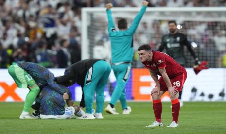 Pemain Liverpool Andy Robertson, kanan, sedih saat para pemain Real merayakan setelah pertandingan sepak bola final Liga Champions antara Liverpool dan Real Madrid di Stade de France di Saint Denis dekat Paris, Sabtu, 28 Mei 2022. Real menang 1-0.