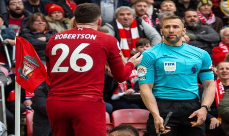 Pemain Liverpool Andrew Robertson (kiri) dengan asisten wasit Constantine Hatzidakis dalam laga Liverpool kontra Arsenal di Liga Primer Inggris.