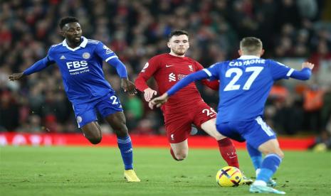 Pemain Liverpool Andy Robertson (tengah) membawa bola melewati pemain Leicester City Wilfred Ndidi (kiri) dan Timothy Castagne dalam pertandingan Liga Primer INggris di Anfield, Sabtu (31/12/2022) dini hari WIB.