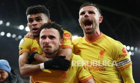  Pemain Liverpool Diogo Jota, bawah, diberi selamat oleh rekan setimnya Luis Diaz, atas, dan Jordan Henderson setelah mencetak gol pertama timnya dalam pertandingan sepak bola Liga Inggris antara Arsenal dan Liverpool di Stadion Emirates di London, Rabu, 16 Maret 2022.