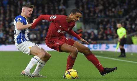 Pemain Liverpool Joel Matip (kanan) berebut bola dengan  pemain Brighton Evan Ferguson (kiri) pada pertandingan sepak bola Liga Utama Inggris antara Brighton dan Hove Albion dan Liverpool FC di Brighton, Inggris, Sabtu (14/1/2023).