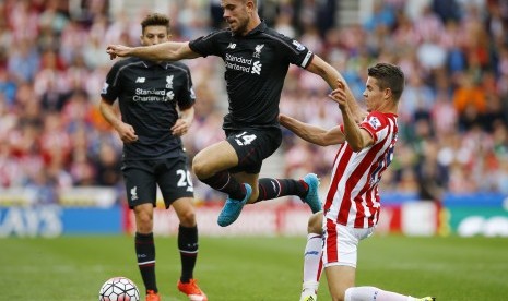 Pemain Liverpool Jordan Henderson beraksi dihadapan pemain Stoke, Marco van Ginkel, dalam laga Stoke City kontra Liverpool, Ahad (9/8)