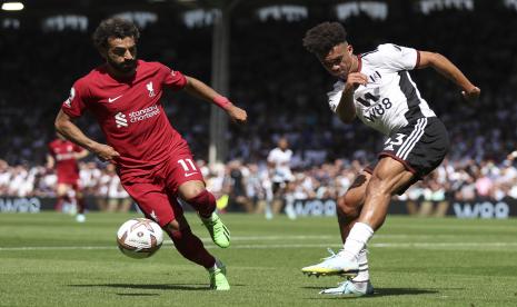  Pemain Liverpool Mohamed Salah (kiri) dan pemain Fulham Antonee Robinson berebut bola dalam pertandingan sepak bola Liga Inggris antara Fulham dan Liverpool di stadion Craven Cottage di London, Sabtu, 6 Agustus 2022. 