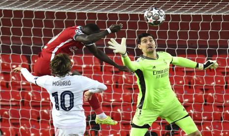 Pemain Liverpool Sadio Mane (C) beraksi menghadapi pemain Real Madrid Luka Modric dan kiper Thibaut Courtois saat  laga leg kedua perempat final di Anfield, Kamis (15/4) dini hari WIB.