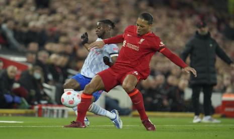 Pemain Liverpool Virgil van Dijk, kanan, berebut bola dengan pemain Manchester United Aaron Wan-Bissaka selama pertandingan sepak bola Liga Inggris antara Liverpool dan Manchester United di stadion Anfield di Liverpool, Inggris, Selasa, 19 April 2022.