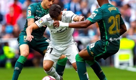 Pemain Madrid berebut bola dengan pemain Real Betis dalam pertandingan di Santiago Bernabeu, Ahad (20/5).