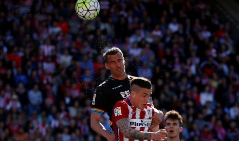 Pemain Madrid Jose Maria Gimenez beradu dengan pemain Rayo Vallecano Antonio Amaya, Sabtu (1/5).