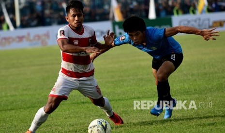 Pemain Madura United Andik Vermansah (kiri) berebut bola dengan pemain Persela Kei Hirose dalam pertandingan babak delapan besar Piala Presiden 2019 di Stadion Surajaya Lamongan, Jawa Timur, Ahad (31/3/2019).