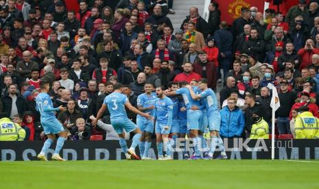  Pemain Manchester City Bernardo Silva ditutupi oleh rekan satu timnya, merayakan setelah mencetak gol kedua timnya pada pertandingan sepak bola Liga Premier Inggris antara Manchester United dan Manchester City di stadion Old Trafford di Manchester, Inggris, Sabtu (6/11/2021).