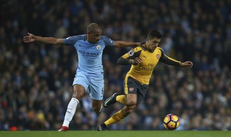 Pemain Manchester City Fernando menjaga pergerakan Alexis Sanchez dalam pertandingan Liga Inggris antara Manchester City menjamu Arsenal di Etihad Stadium, Ahad (18/12). 