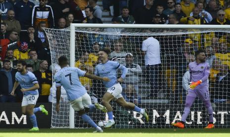 Pemain Manchester City Jack Grealish, kanan, merayakan setelah mencetak gol pembuka pada pertandingan sepak bola Liga Inggris antara Wolverhampton Wanderers dan Manchester City di Stadion Molineux di Wolverhampton, Inggris, Sabtu, 17 September 2022. 