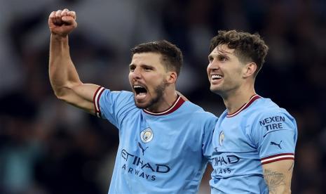 Pemain Manchester City John Stones (kanan) dan Ruben Dias berselebrasi selepas mengalahkan Real Madrid 4-0 dalam leg kedua semifinal Liga Champions, Kamis (16/5/2023). City lolos ke final dengan agregat 5-1 dan akan berhadapan dengan Inter Milan.