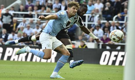 Pemain Manchester City John Stones, kiri, menantang pemain Newcastle Allan Saint-Maximin dalam pertandingan sepak bola Liga Inggris antara Newcastle United dan Manchester City di St James Park di Newcastle, Inggris, Ahad, 21 Agustus 2022. 