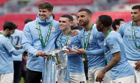 Pemain Manchester City John Stones, Phil Foden, Kyle Walker dan Raheem Sterling, dari kiri ke kanan, berpose dengan trofi di penghujung pertandingan final Piala Liga Inggris antara Manchester City melawan Tottenham Hotspur di stadion Wembley di London, Minggu, April 25, 2021. Manchester City menang 1-0.