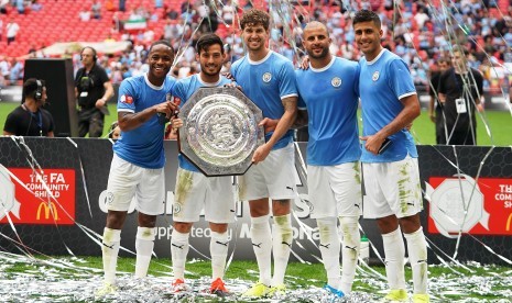 Pemain Manchester City (LR) Raheem Sterling, David Silva, John Stones, Kyle Walker, dan Rodrigo Hernandez berpose bersama trofi setelah memenangkan pertandingan sepak bola FA Community Shield antara Liverpool FC dan Manchester City di Stadion Wembley di London, Inggris, Ahad (4/8).