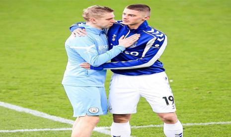 Pemain Manchester City Oleksandr Zinchenko (kiri) dan pemain Everton Vitaly Mykolenko (kanan) berpelukan jelang laga kedua tim, Sabtu (26/2/2022). Kedua pemain adalah warga Ukraina. 