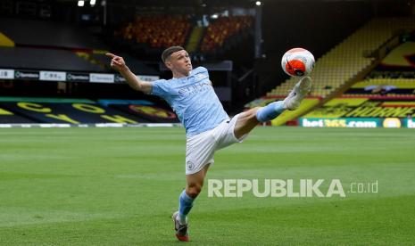  Pemain Manchester City Phil Foden menendang bola pada pertandingan sepak bola Liga Primer Inggris antara Watford dan Manchester City di Vicarage Road Stadium di Watford, Inggris, Selasa (21/7/2020). 