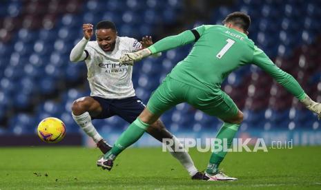 Pemain Manchester City Raheem Sterling (kiri) mengecoh kiper Burnley Nick Pope (kanan) pada pertandingan sepak bola Liga Premier Inggris antara Burnley FC dan Manchester City di Burnley, Inggris, Kamis (4/2) dini hari WIB 