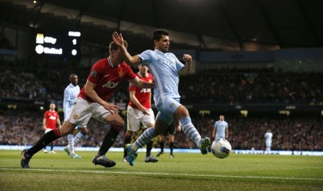 Pemain Manchester City, Sergio Aguero (kanan) berebut bola dengan pemain Manchester United, Phil Jones dalam Derby Manchester, Senin (30/4) 2012 di Etihad Stadium. 