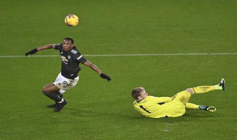  Pemain Manchester United Anthony Martial, mendribel bola melewati penjaga gawang Sheffield United Aaron Ramsdale, dalam perjalanannya untuk mencetak gol selama pertandingan sepak bola Liga Primer Inggris antara Sheffield United dan Manchester United di Stadion Bramall Lane di Sheffield, Inggris, Kamis, 17 Desember 2020. Manchester United memenangkan pertandingan 3-2. 