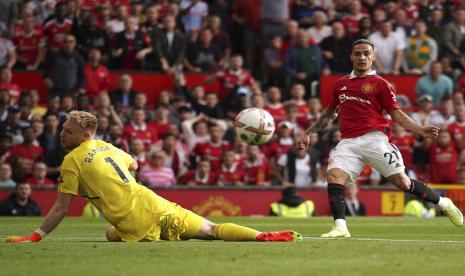 Pemain Manchester United Antony, kanan, mencetak gol pembuka timnya melewati kiper Arsenal Aaron Ramsdale selama pertandingan sepak bola Liga Inggris antara Manchester United dan Arsenal di stadion Old Trafford, di Manchester, Inggris, Ahad, 4 September 2022. 