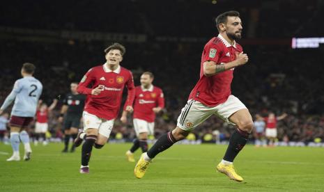 Pemain Manchester United Bruno Fernandes, kanan, merayakan setelah mencetak gol ketiga timnya selama pertandingan sepak bola putaran ketiga Piala Liga Inggris antara Manchester United dan Aston Villa di Manchester, Inggris, Jumat (11/11/2022).