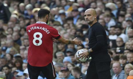  Pemain Manchester United Bruno Fernandes (kir) meminta bola kepada pelatih kepala Manchester City Pep Guardiola selama pertandingan sepak bola Liga Inggris antara Manchester City dan Manchester United di stadion Etihad di Manchester, Inggris, Ahad, 2 Oktober 2022.