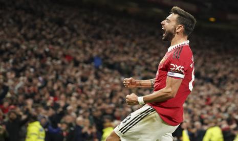 Gelandang Manchester United (MU) Bruno Fernandes merayakan setelah mencetak gol kedua timnya selama pertandingan perempat final antara MU dan Fulham di Old Trafford, Manchester, Inggris, Ahad (19/3/2023). Fernandes menyumbang dua gol kemenangan MU 3-1 atas Fulham di laga itu.  