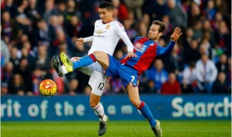 Pemain Manchester United Chris Smalling (putih) berebut bola dengan gelandang Crystal Palace Yohan Cabaye.