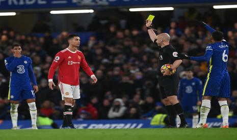 Pemain Manchester United Cristiano Ronaldo (2-Kiri) mendapat kartu kuning dari wasit Anthony Taylor (2-kanan) pada pertandingan sepak bola Liga Inggris antara Chelsea FC dan Manchester United di London, Inggris, 28 November 2021.