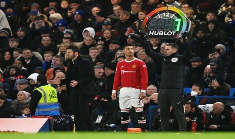 Pemain Manchester United Cristiano Ronaldo (tengah) berdiri di sebelah manajer Michael Carrick (kiri) sambil menunggu untuk masuk selama pertandingan sepak bola Liga Premier Inggris antara Chelsea FC dan Manchester United di London, Inggris, 28 November 2021.