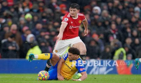  Kapten Manchester United Harry Maguire (belakang) menantang pemain Southampton Che Adams saat pertandingan sepak bola Liga Inggris antara Manchester United dan Southampton di stadion Old Trafford di Manchester, Inggris, Sabtu (12/2/2022). 