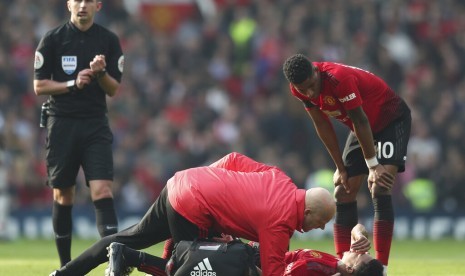 Pemain Manchester United Jesse Lingard terbaring di lapangan akibat cedera.